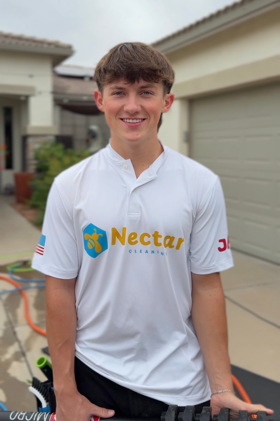 Christian Bindas, owner of Nectar Window Cleaning, in his Nectar shirt outside an Arizona property